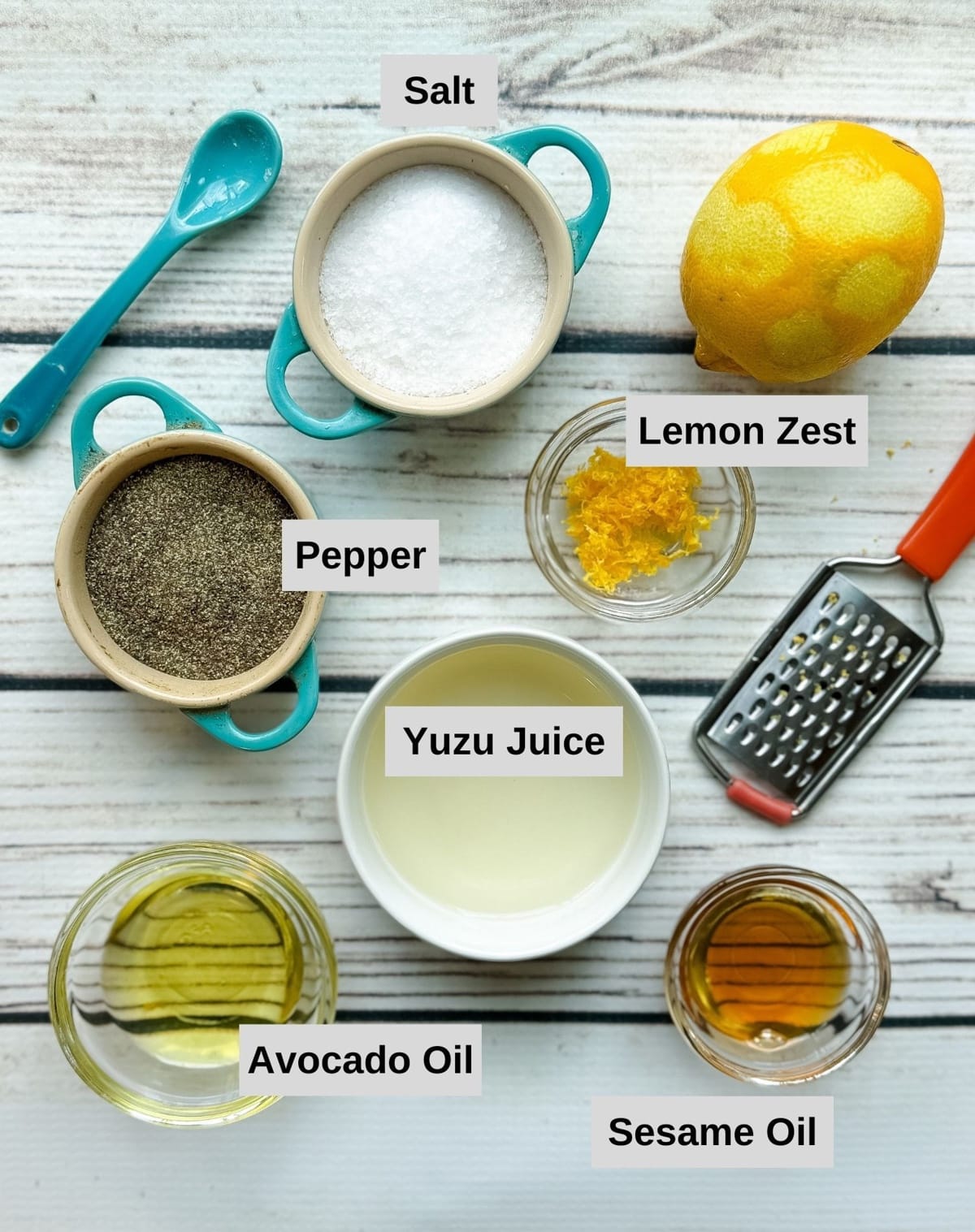 Labeled ingredients in small bowls on a white wooden board for making the dressing for spicy hamachi yellowtail crudo.