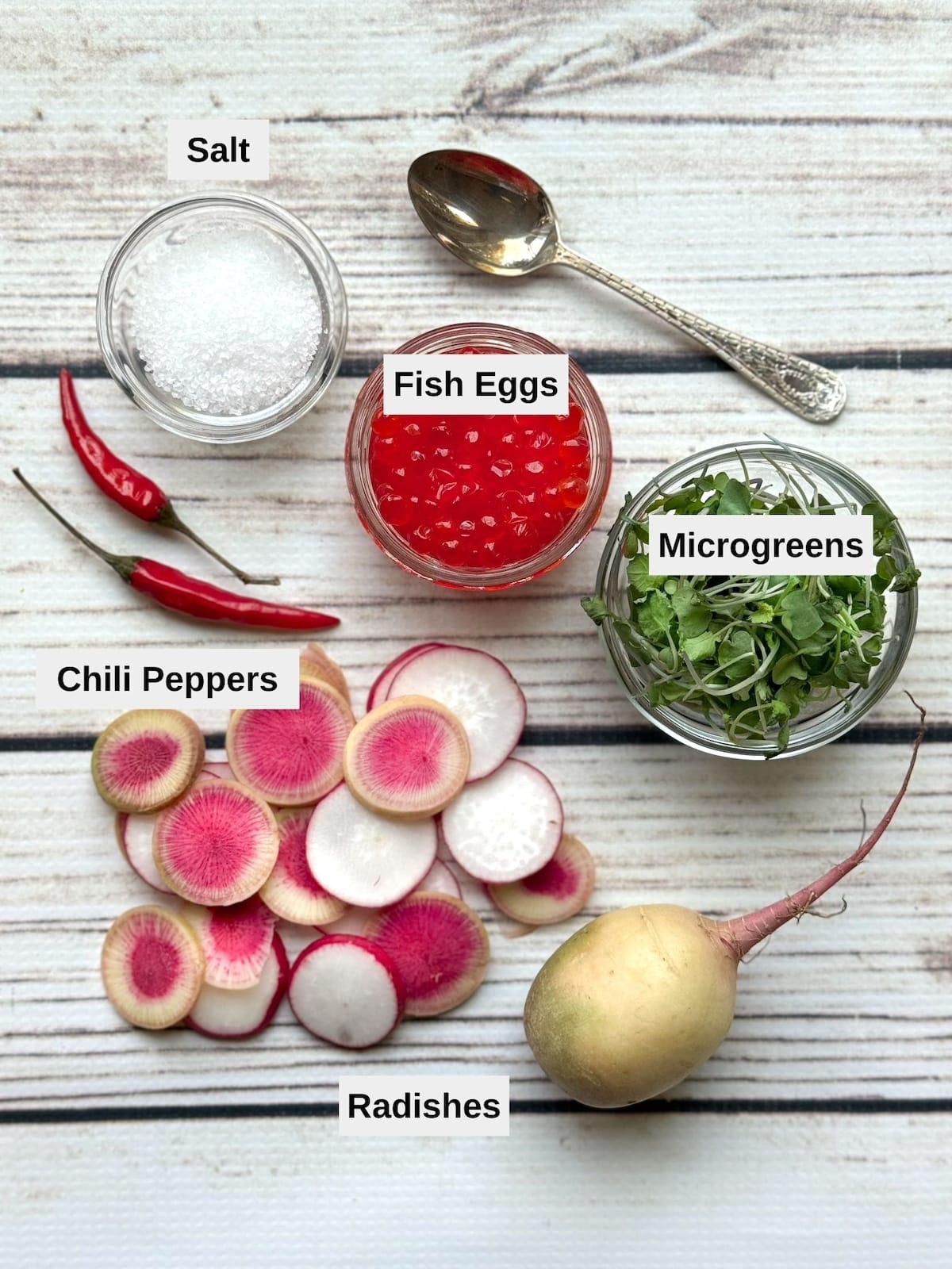 Labeled ingredients for the toppings for spicy hamachi yellowtail crudo on top of a white board.